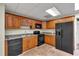 A cozy basement kitchen features wooden cabinets and black appliances, providing practical and convenient amenities at 4565 Canebrake Ct, Powder Springs, GA 30127