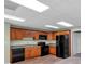 A cozy basement kitchen features wooden cabinets and black appliances, providing practical and convenient amenities at 4565 Canebrake Ct, Powder Springs, GA 30127