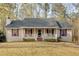 Charming single-story home featuring a welcoming front porch with red shutters and a well-maintained yard at 4565 Canebrake Ct, Powder Springs, GA 30127