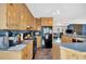 Well-lit kitchen features natural wood cabinets, black appliances, and an open layout to the living area at 4565 Canebrake Ct, Powder Springs, GA 30127