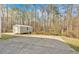 Exterior view of the backyard shed with concrete foundation and wooded scenery at 4565 Canebrake Ct, Powder Springs, GA 30127