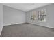 Bright bedroom with neutral carpet, gray walls, white trim, and two windows providing ample natural light at 5219 Sweet Air Ln, Stone Mountain, GA 30088