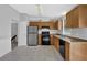 Well-lit kitchen featuring wood cabinets, tile flooring, and stainless-steel refrigerator and stove at 5219 Sweet Air Ln, Stone Mountain, GA 30088
