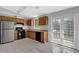 Well-lit kitchen features stainless steel refrigerator, oak cabinets, black appliances, and access to the outside at 5219 Sweet Air Ln, Stone Mountain, GA 30088