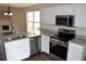 Kitchen with stainless steel appliances, granite countertops, white cabinets, and wood flooring at 253 Woodland Way, Canton, GA 30114