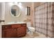 Bathroom features a cherry wood vanity, oval mirror, tiled floor, and a shower with decorative curtain at 2766 Birch Grove Se Ln # 11, Marietta, GA 30067