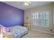 Bright bedroom with a purple accent wall, ceiling fan, and shuttered window allowing for natural light at 2766 Birch Grove Se Ln # 11, Marietta, GA 30067