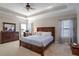 Comfortable main bedroom with soft carpet, ceiling fan, and windows with decorative curtains at 2766 Birch Grove Se Ln # 11, Marietta, GA 30067