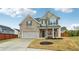 Inviting two-story home featuring a brick facade, attached garage, and covered front porch with swing at 4443 Quilter St, Powder Springs, GA 30127
