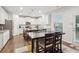Bright kitchen with white cabinets, a large island, and an adjacent dining area with a modern table at 4443 Quilter St, Powder Springs, GA 30127