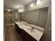 Bathroom featuring dual sinks, a large mirror, walk-in shower, and neutral color scheme at 100 Iverson Pl, Temple, GA 30179
