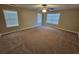 Large bedroom with neutral carpet, ample natural light from three windows, and a ceiling fan at 100 Iverson Pl, Temple, GA 30179