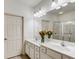Bathroom featuring dual sinks, white cabinets, and a glass-enclosed shower at 1045 Brook Knoll Ln # 401, Cumming, GA 30041