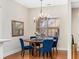 Bright dining area with a round wooden table, complemented by stylish blue chairs and a decorative chandelier at 1045 Brook Knoll Ln # 401, Cumming, GA 30041