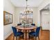 Elegant dining room with a round table, blue chairs, chandelier, and a view to the neighborhood at 1045 Brook Knoll Ln # 401, Cumming, GA 30041