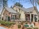 A charming home with brick and siding, featuring a black fence, lush greenery, and well-maintained landscaping at 1045 Brook Knoll Ln # 401, Cumming, GA 30041
