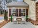 Cozy front porch with seating area, featuring two chairs, a small table, and decorative plants at 1045 Brook Knoll Ln # 401, Cumming, GA 30041