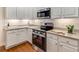 Modern kitchen with stainless steel appliances, white cabinets, and granite countertops at 1045 Brook Knoll Ln # 401, Cumming, GA 30041