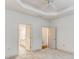 Spacious bedroom featuring tray ceiling, carpet floors, and ensuite bathroom entrance at 1045 Brook Knoll Ln # 401, Cumming, GA 30041