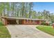 A well-maintained brick home featuring a covered carport and a concrete driveway at 1933 Silvastone Dr, Decatur, GA 30033