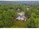 A sprawling home with lush greenery is surrounded by trees and a circular driveway, providing privacy and curb appeal at 3545 Silver Vista Ct, Cumming, GA 30041