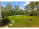 Expansive backyard with lush green grass, a fire pit area, and a tree-lined perimeter at 3545 Silver Vista Ct, Cumming, GA 30041