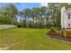 A spacious lawn is surrounded by lush greenery, framed by mature trees, and has a nice garden bed at 3545 Silver Vista Ct, Cumming, GA 30041