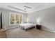 Sunlit bedroom featuring a tray ceiling, large windows, and neutral decor at 3545 Silver Vista Ct, Cumming, GA 30041
