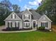 Charming gray two-story home with manicured lawn, black shutters and a walkway to an arched front door at 3545 Silver Vista Ct, Cumming, GA 30041