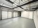 Large garage with three doors, an entrance door, high ceilings and shelving units at 3545 Silver Vista Ct, Cumming, GA 30041