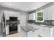 Well-lit kitchen featuring white cabinets, stainless steel appliances, granite countertops, and a tile backsplash at 3545 Silver Vista Ct, Cumming, GA 30041
