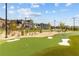 Community putting green with professionally manicured lawn, mature trees, and decorative lighting at 3545 Silver Vista Ct, Cumming, GA 30041