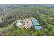 Panoramic aerial view showcasing community amenities including a pool, tennis courts, playground, and clubhouse amidst trees at 6635 Canyon Cv, Cumming, GA 30028
