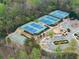 Aerial view of community tennis courts, playground, and parking area, surrounded by lush greenery and mature trees at 6635 Canyon Cv, Cumming, GA 30028