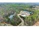 Stunning aerial view showcasing a community pool, tennis courts, and a tranquil pond surrounded by lush greenery at 6635 Canyon Cv, Cumming, GA 30028
