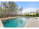 Serene backyard pool surrounded by lush greenery and privacy fencing, creating a tranquil oasis for relaxation at 6635 Canyon Cv, Cumming, GA 30028