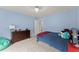 Cozy blue bedroom with a dark dresser and blue bedsheets at 6635 Canyon Cv, Cumming, GA 30028