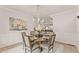 Elegant dining room with a round table, chandelier, and wainscoting at 6635 Canyon Cv, Cumming, GA 30028