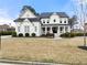 Stunning white home with a covered porch, black roof, and lush front lawn at 6635 Canyon Cv, Cumming, GA 30028