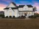 Elegant white home with a welcoming front porch and manicured landscaping at 6635 Canyon Cv, Cumming, GA 30028