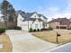 Beautiful white home featuring a three-car garage and well-maintained front yard at 6635 Canyon Cv, Cumming, GA 30028
