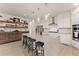 Bright kitchen features a center island with seating, stainless steel appliances, and custom shelving at 6635 Canyon Cv, Cumming, GA 30028