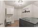 The laundry room features sink, cabinets, shelving above the washer and dryer at 6635 Canyon Cv, Cumming, GA 30028