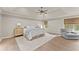 Spacious primary bedroom with tray ceiling, sitting area, and natural light at 6635 Canyon Cv, Cumming, GA 30028
