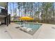 Backyard pool with lounge chairs, mature trees, and backyard view of house at 6635 Canyon Cv, Cumming, GA 30028