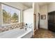 Bright bathroom area featuring a soaking tub under a window, tile accents and dark door at 2195 Well Springs Dr, Buford, GA 30519