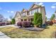 Attractive home exterior with lush green lawn, stone features, and a well-kept landscape at 2195 Well Springs Dr, Buford, GA 30519