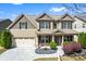 Charming two-story home featuring a manicured lawn, stone accents, and a welcoming front porch at 2195 Well Springs Dr, Buford, GA 30519