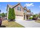 Beautiful home exterior showcases a well-maintained lawn, two-car garage, and complementary landscaping at 2195 Well Springs Dr, Buford, GA 30519