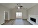 Well-lit living room with a large window, ceiling fan, hardwood floors, and a cozy fireplace at 3245 Country Walk Dr, Powder Springs, GA 30127